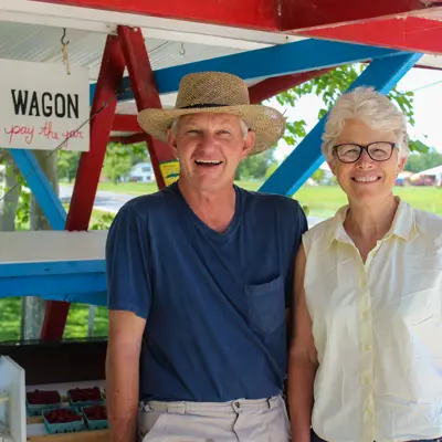 couple standing in front of road side produce stand